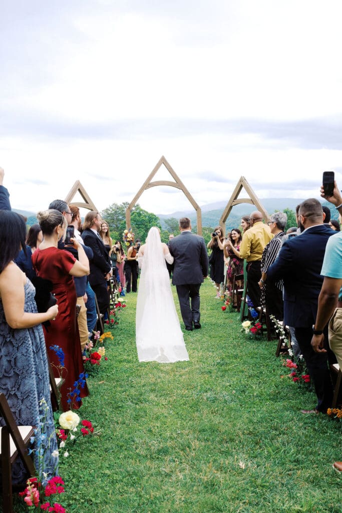 Bride walking down the aisle at outdoor ceremony at Harper’s Vineyard.
