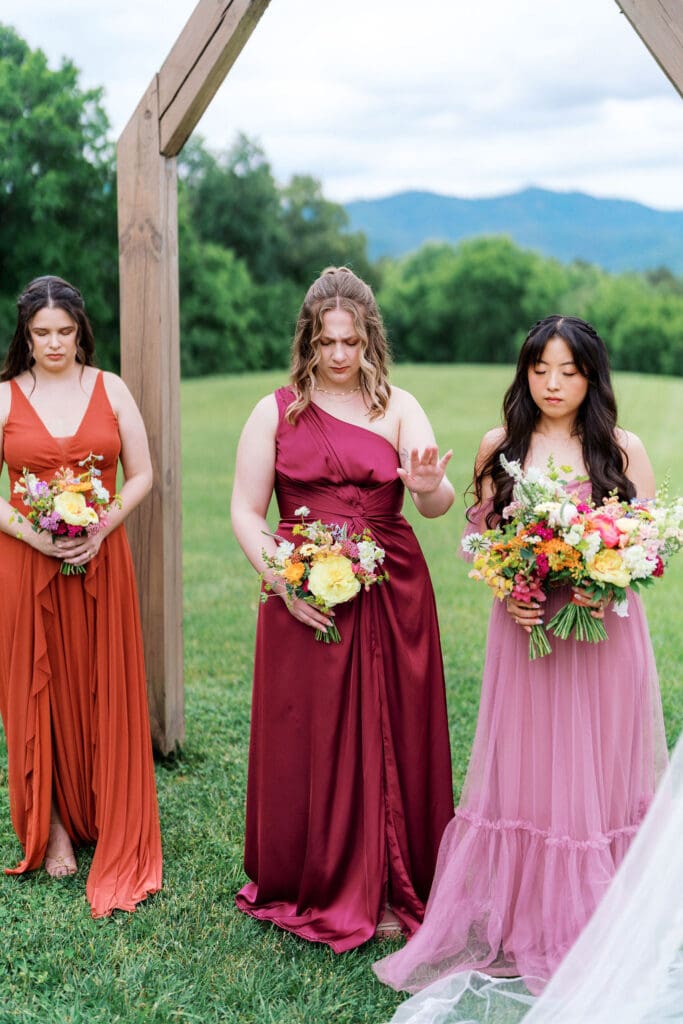 Wedding ceremony under wooden arch with floral arrangements at Harper’s Vineyard.