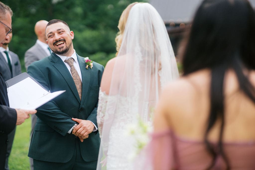 Emotional groom seeing bride for the first time at vineyard ceremony.