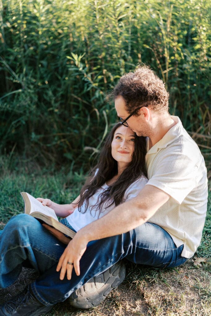 Knoxville couple sits in field for engagement photos at Seven Islands State Birding Park