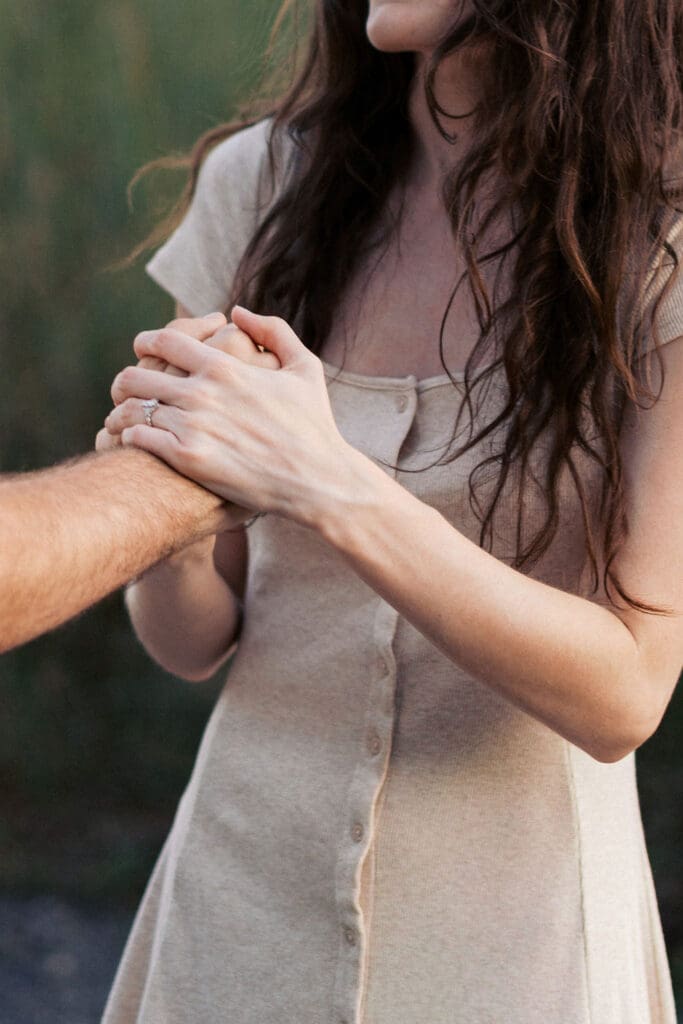 couple holds hands during golden hour at seven islands state birding park in knoxville tennessee