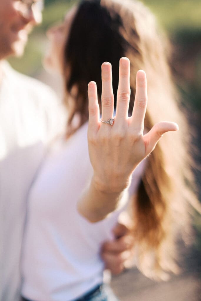 woman shows off engagement ring at seven islands park in knoxville tennessee during summer engagement photos