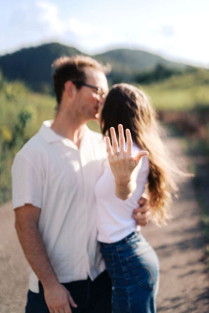 woman shows off engagement ring at seven islands park in knoxville tennessee during summer engagement photos