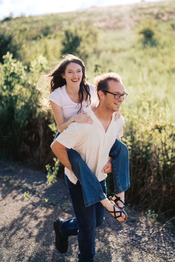 couple runs down walking trail at seven islands park in knoxville tn for summer engagement photos