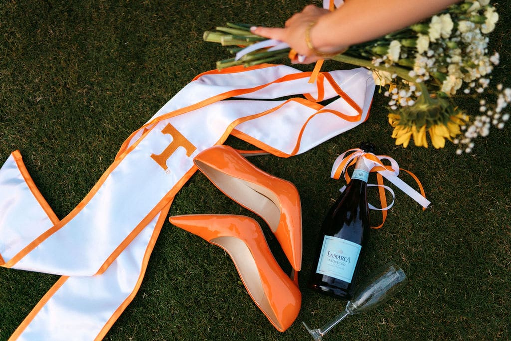 orange heels and champagne and flowers on the grass at the university of tennessee knoxville