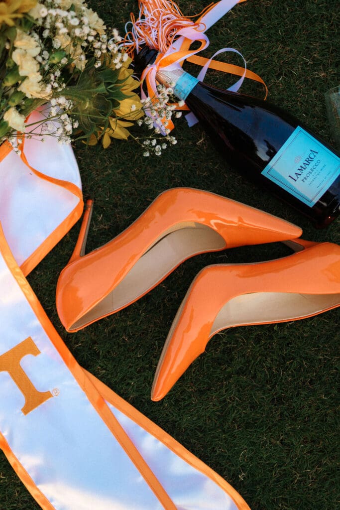orange heels and champagne and flowers on the grass at the university of tennessee knoxville