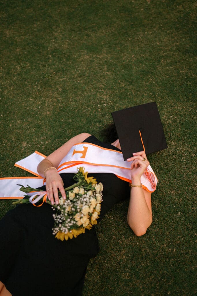 girl laying down on HSS lawn during her senior photo session at the University of Tennessee Knoxville