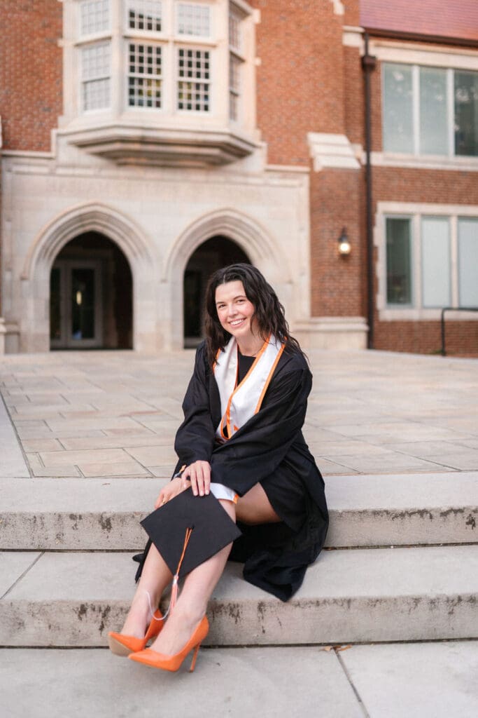 marketing graduate of the university of tennessee knoxville sits in front of the haslam college of business for senior photos