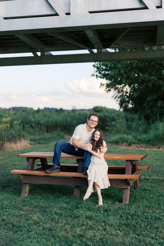 couple sits on bench at seven islands state birding park in knoxville tennessee