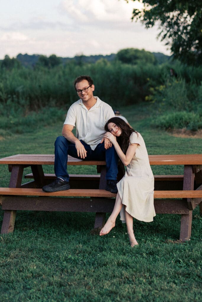 couple sits on bench at seven islands state birding park in knoxville tennessee