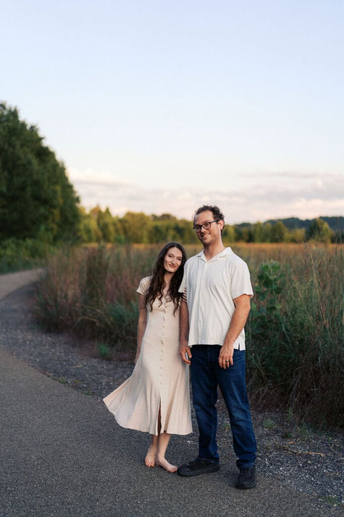 couple holds hands in front of field at seven islands state birding park in knoxville tennessee
