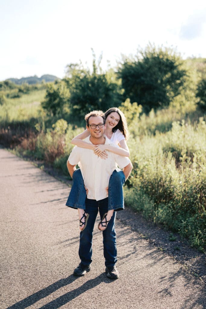 couple runs down walking trail at seven islands park in knoxville tn for summer engagement photos