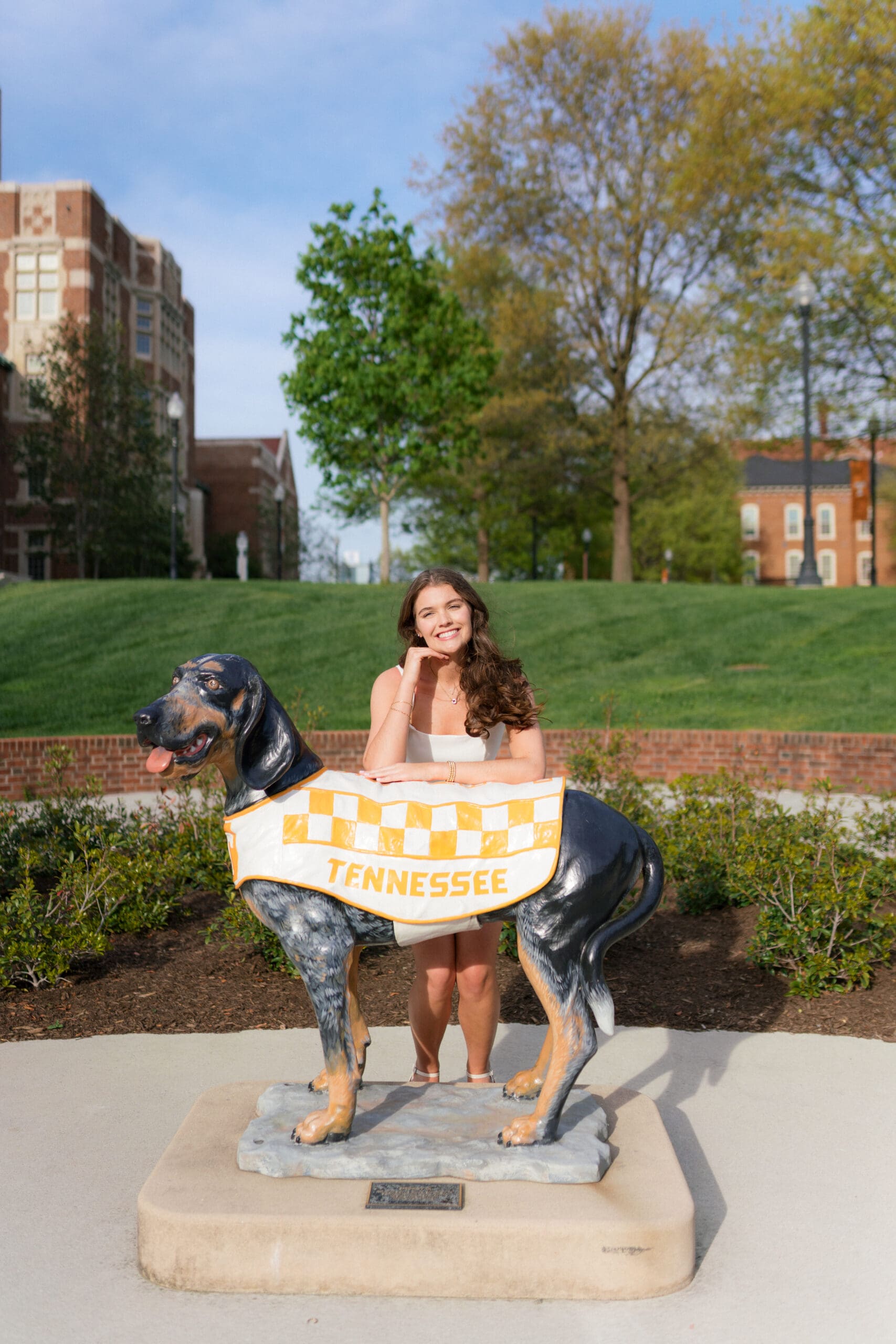 girl stands by a smokey the dog statue during senior photos at the university of tennessee knoxville