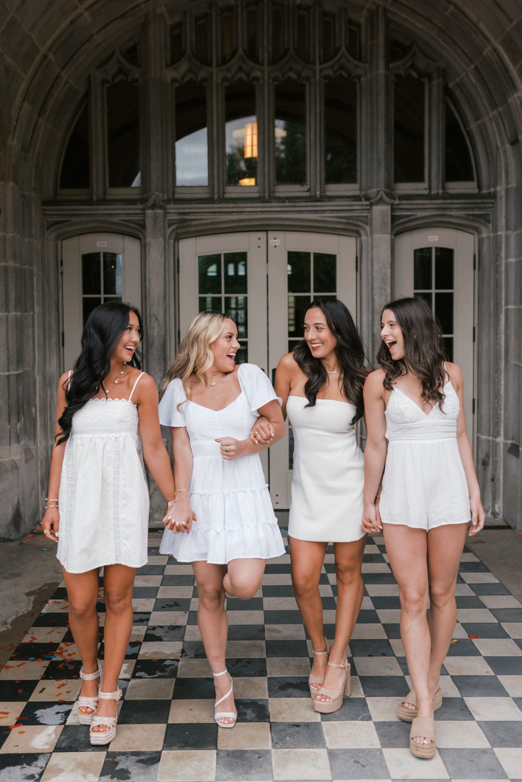 a group of girls in white dresses pose at ayres hall for graduation photos at the university of tennessee knoxville