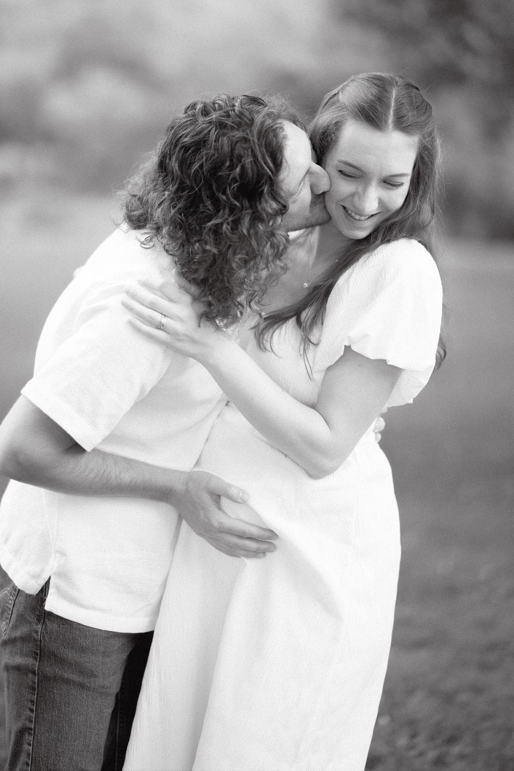 Expecting couple dancing and kissing in field during maternity session at Cove Lake State Park, Tennessee