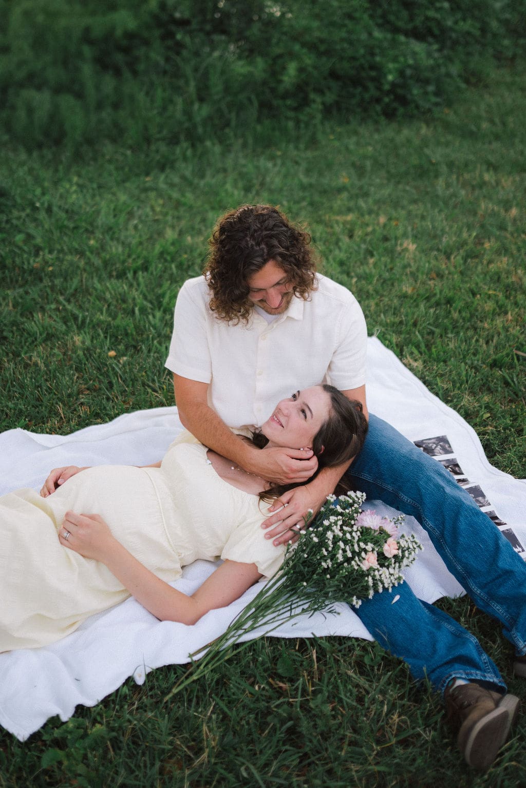 Couple lays on picnic blanket during maternity session in East Tennessee.