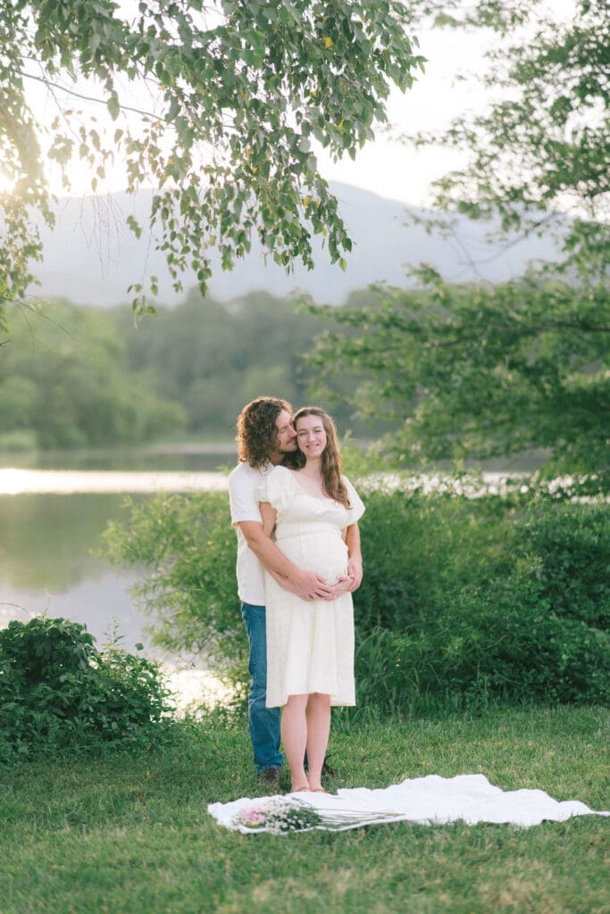 Candid maternity photo of couple embracing during golden hour at Cove Lake State Park, captured by Knoxville photographer