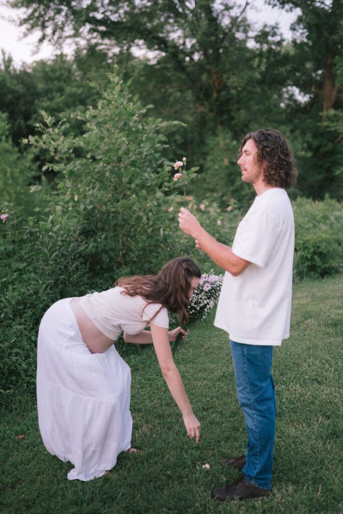 Candid photo of a couple picking flowers during maternity photos in Knoxville Tennessee