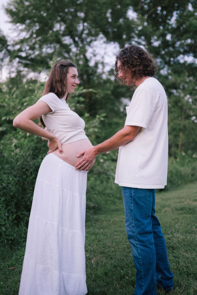 Husband holds wife's pregnant belly during maternity photo session in Knoxville Tennessee