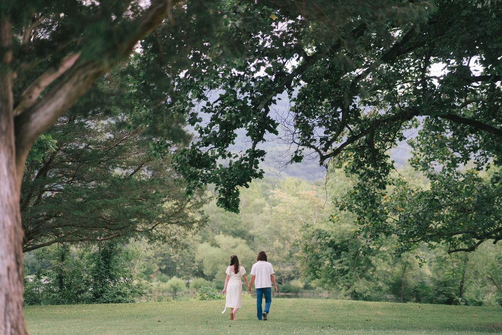Couple walking toward water during maternity session at Cove Lake State Park, Tennessee